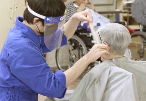 スタッフが高齢者に対して医療処置または検査を行っている場面