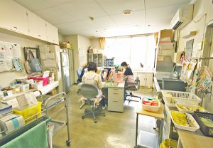 職員室・事務室。スタッフが業務を行う空間で、デスク・書類・掲示物が見られます。